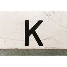 Large black polyester letter "K" marking a floor.