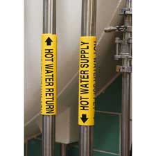 Two pipes with yellow Brady snap-on pipe markers reading "Hot Water Return" and "Hot Water Supply" secured to them.