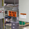Toma aérea de cajas y equipos eléctricos en una planta con diferentes voltajes, arco eléctrico y etiquetas de identificación aplicadas.